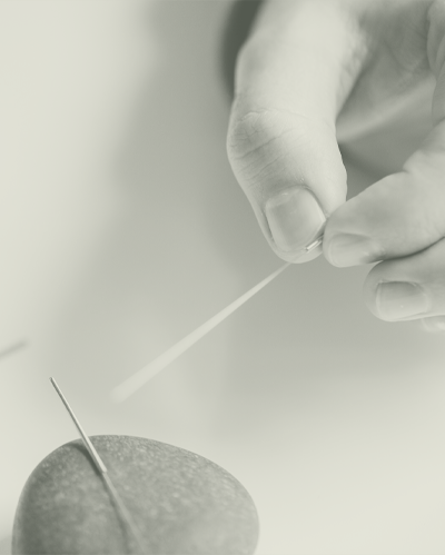 Acupuncture Hand Holding Acupuncture Needle Above Stone